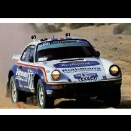 A white rally car with blue and red livery, featuring prominent 'Rothmans' and 'Texaco' sponsor logos, driving on a dusty desert track. Beemax Porsche 911 Paris Dakar Winner 1984 1:24 Scale Plastic Model Kit