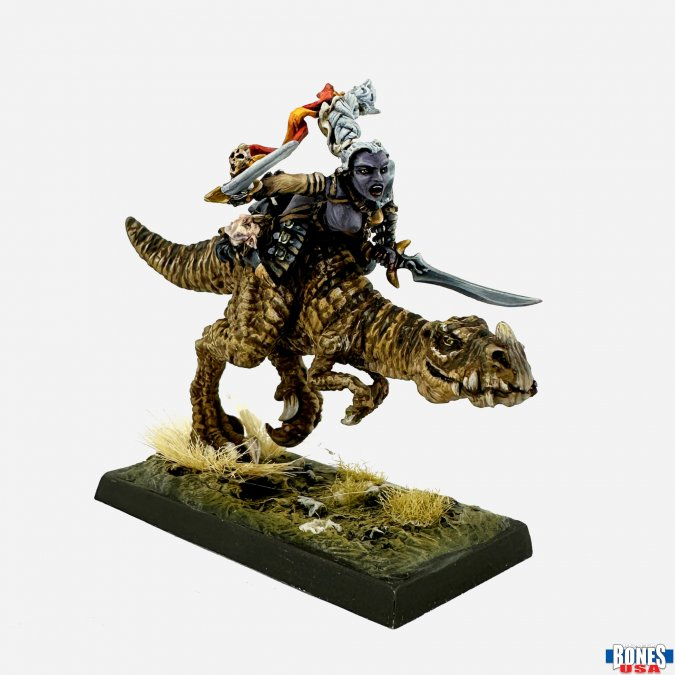 Female Dark Elf on Lizard (30220). A striking Bones USA miniature featuring a dark elf warrior wielding dual swords atop a fierce lizard mount. Requires assembly, unpainted.
