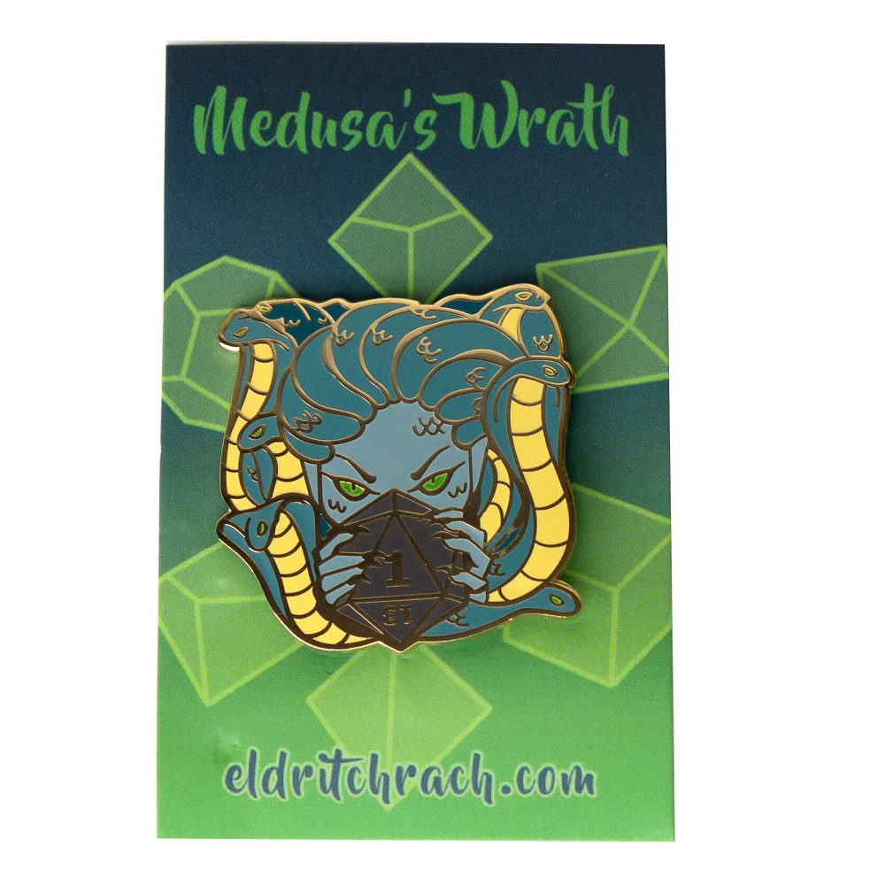 Enamel pin badge titled Medusa's Wrath, depicting Medusa's blue face with green eyes, yellow snake hair, and a black D20 die. Includes a themed backing card.