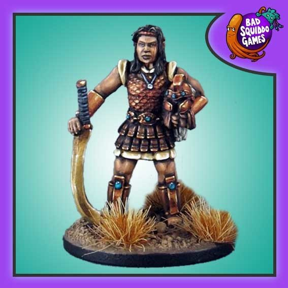 Bad Squiddo Games metal gaming figure. Amazon warrior, Holding her helmet under her arm and weapon resting blade down on the ground.