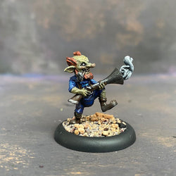 Boom Boom McBoom from the Moonstone mushroom and mayhem troupe box,  pre painted by Mrs MLG. This wonderfully sculpted miniature is of a Goblin holding a rather large smoking gun, with a pipe in his mouth and wonderful grin on his face. This delicate miniature is painted with greens, blues and browns. 