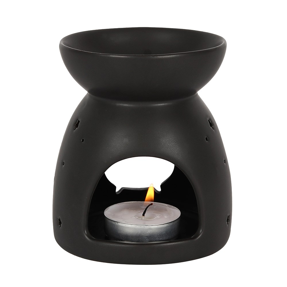 A matt black oil burner with a cut out bubbling cauldron design
