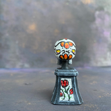 Prepainted Sugar Skull from the Reaper Miniatures bones USA range hand painted by Mrs MLG, a brightly coloured skull on a plinth. 