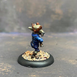 Boom Boom McBoom from the Moonstone mushroom and mayhem troupe box,  pre painted by Mrs MLG. This wonderfully sculpted miniature is of a Goblin holding a rather large smoking gun, with a pipe in his mouth and wonderful grin on his face. This delicate miniature is painted with greens, blues and browns. 