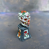 Prepainted Sugar Skull from the Reaper Miniatures bones USA range hand painted by Mrs MLG, a brightly coloured skull on a plinth. 