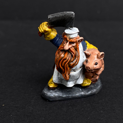 Hand painted dwarf butcher from the Reaper Miniatures range. Mrs MLG has painted this dwarf butcher with a yellow, blue and white colour scheme with a vibrant beard holding a clever above his head and a cute pig under his arm. 
