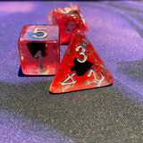 Shape of My Heart Spades. These unusual dice have silver numbers and contain a black spade shape upon a bed of red and gold shimmer.