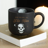 A black mug with a white skull p...