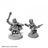 07104 Halfling Ranger & Rogue sculpted by Derek Schubert from the Reaper Miniatures Bones USA Dungeon Dwellers range. A set of two Halfling RPG miniatures one representing a ranger holding a sling in the air, the other a female rogue with a dagger making a great edition to your gaming table.