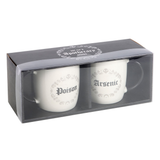 A set of two white mugs with a black handle and inside featuring a grey circle pattern with crescent moon, swirls and skull design with one mug having the word Poison and the other saying Arsenic in black writing. Sold as a set of two mugs with a 350ml capacity to add a little dark humour to your morning coffee.