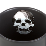 A black mug with a white skull pattern inside and the words Drink At Your Own Risk in gold &amp; white written on the outside with moon and stars showing everyone not to use your mug.