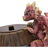 Dragon Heist Money Box by Nemesis Now. A cute little red and gold dragon clinging to the side of a barrel that has the word Bank in gold on the side.