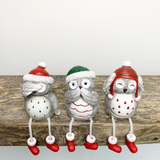Grey Nordic Hear No Evil, See No Evil, Speak No Evil Sitting Christmas Owls With Dangling Legs. An adorable set of three sitting owls wearing festive hats