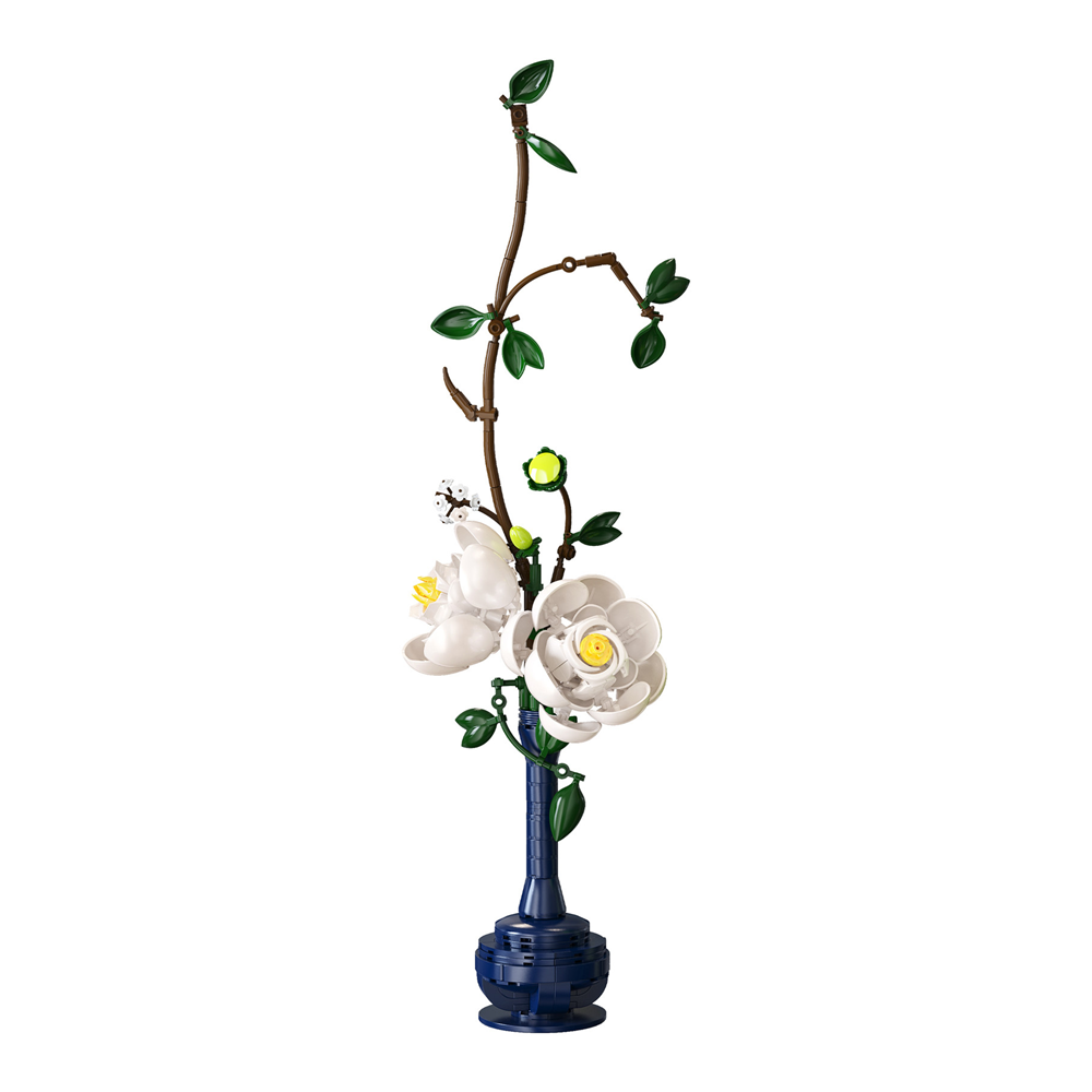 A decorative floral arrangement featuring white magnolia-style flowers with yellow centres, green leaves, and a brown branch, set in a tall dark blue vase against a plain white background. CaDA ARTIZAN EASTERN FLORAL ART building brick floral display