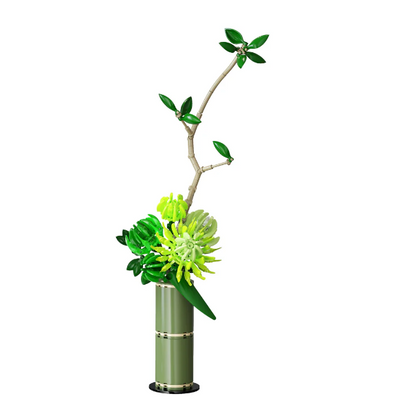 An artificial floral arrangement featuring a tall, slender branch with glossy green leaves and a bright green and yellow flower, set in a cylindrical sage green vase with gold-toned bands, isolated on a white background. CaDA Calm Harmony Artizan Eastern Floral Art - Building Brick Kit