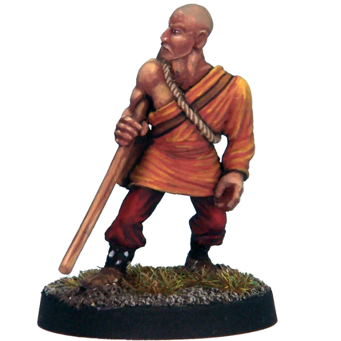 White metal miniature of a human male monk in robes, holding a quarter-staff and carrying a bedroll. Supplied unpainted with 25mm slottabase.