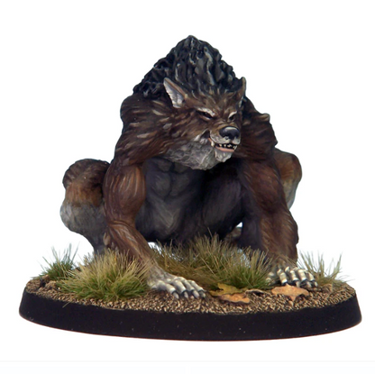 Statue of a werewolf sitting on a rock with grass and leaves on a white background. Crooked Dice Werewolf white metal horror creature miniature with 40mm round base unpainted
