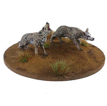 Two wolf figurines on a round base with grass texture. Dead Man’s Hand Pack of Coyotes 28mm