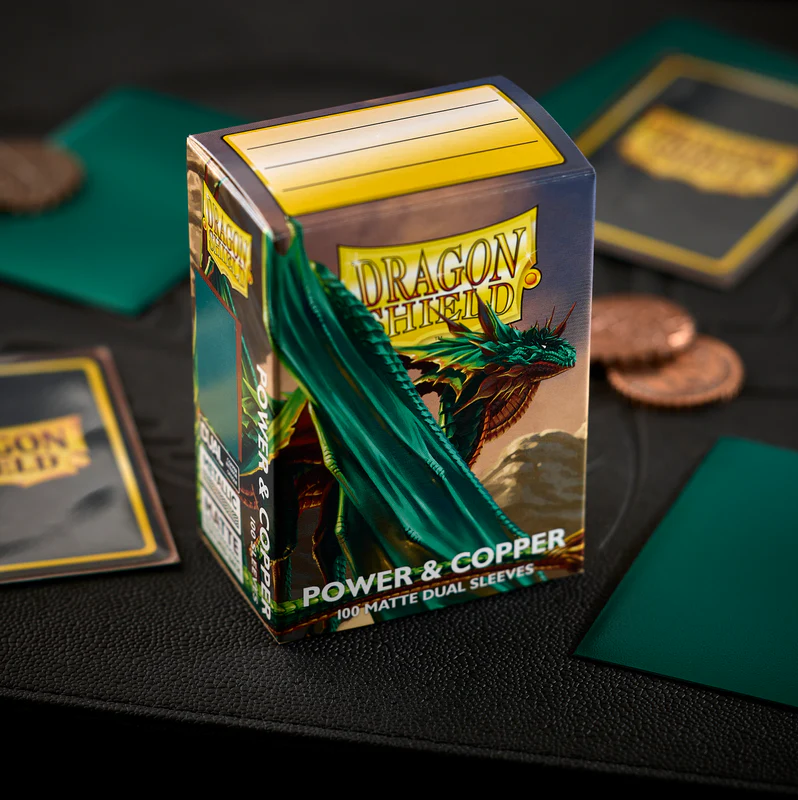 Dragon Shield Power & Copper 100 Matte Dual Sleeves box, featuring a green dragon illustration on a dark background with a yellow brand logo. Dragon Shield Power & Copper Matte Dual Sleeves
