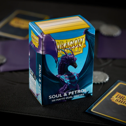 Dragon Shield card sleeves packaging on a dark surface with cards around. Dragon Shield Soul & Petrol Matte Dual Sleeves