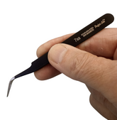 Hand holding a pair of black twe...