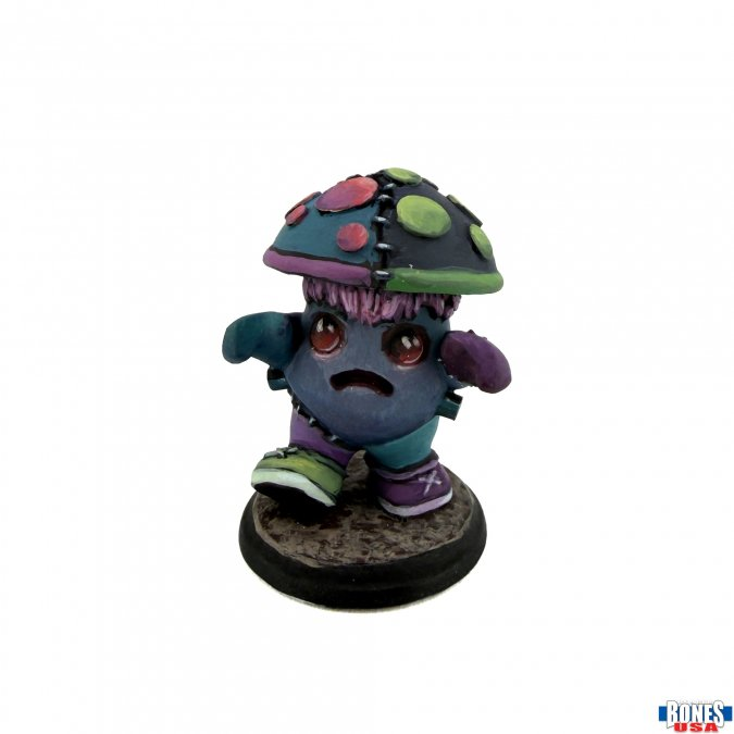 A small fantasy figurine of a stitched, sad creature wearing a mushroom cap and colorful clothing, standing on a round base against a white background.