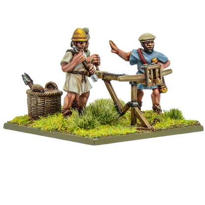 Warlord Games Hail Caesar Hellenistic Greek light artillery bolt thrower 28mm metal miniature with crew. Two miniature figures of Roman soldiers with a crossbow stand on a grassy base.