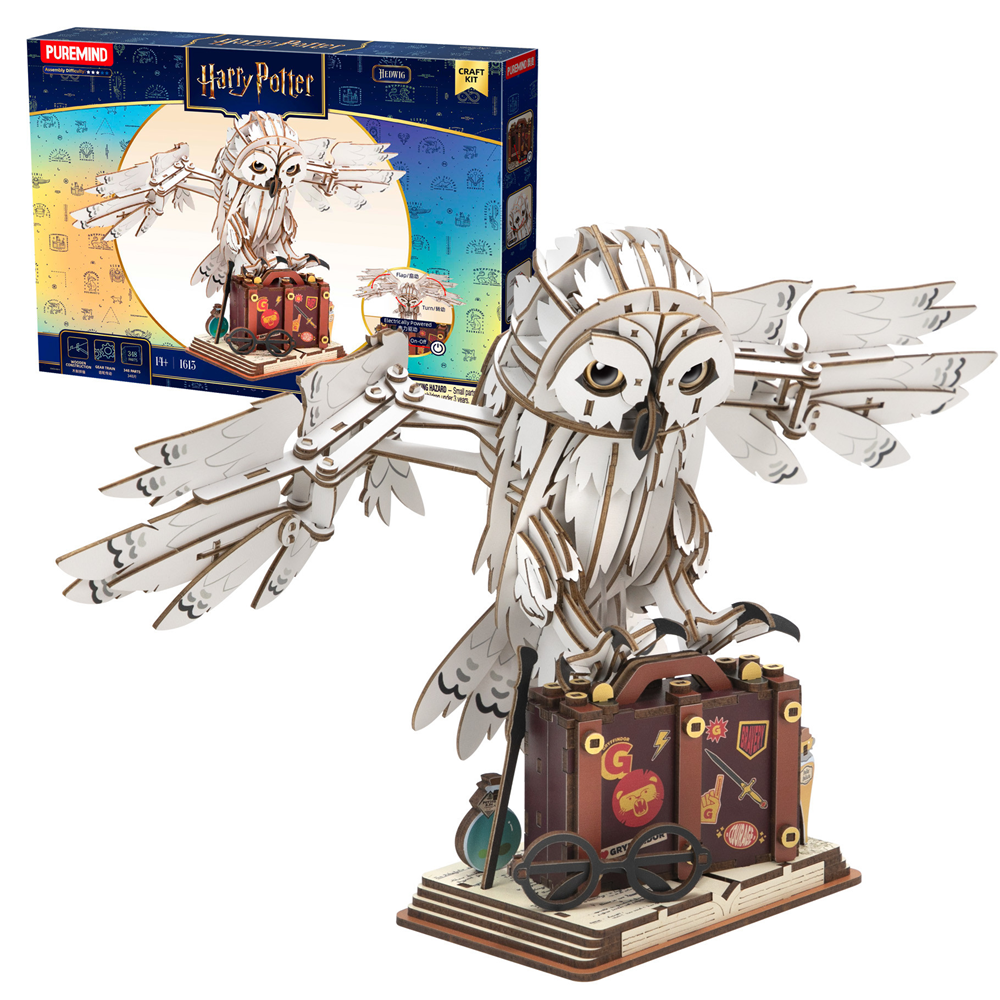 Metal model of an owl with a suitcase and packaging in the background. Harry Potter Mechanical Hedwig wooden model kit
