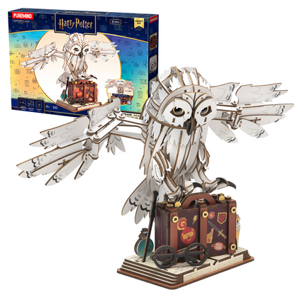 Metal model of an owl with a suitcase and packaging in the background. Harry Potter Mechanical Hedwig wooden model kit