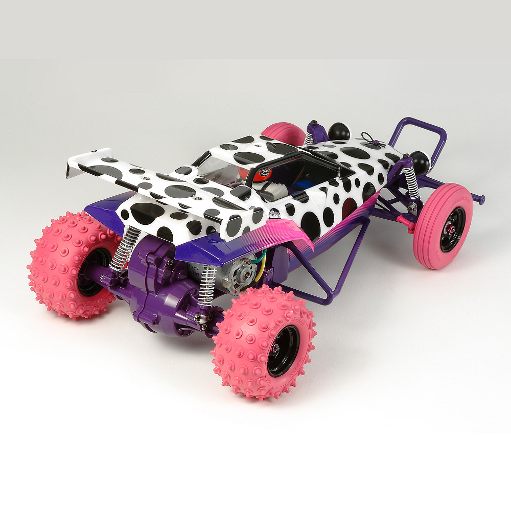 Jun Watanabe Hornet By Tamiya. Remote control car with cow print body and pink spiky wheels on a white background