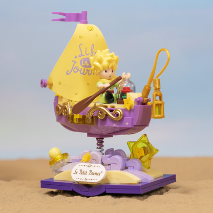 Toy sailboat with a character on a sand and blue sky background. Le Peti Starry Ride Boat
