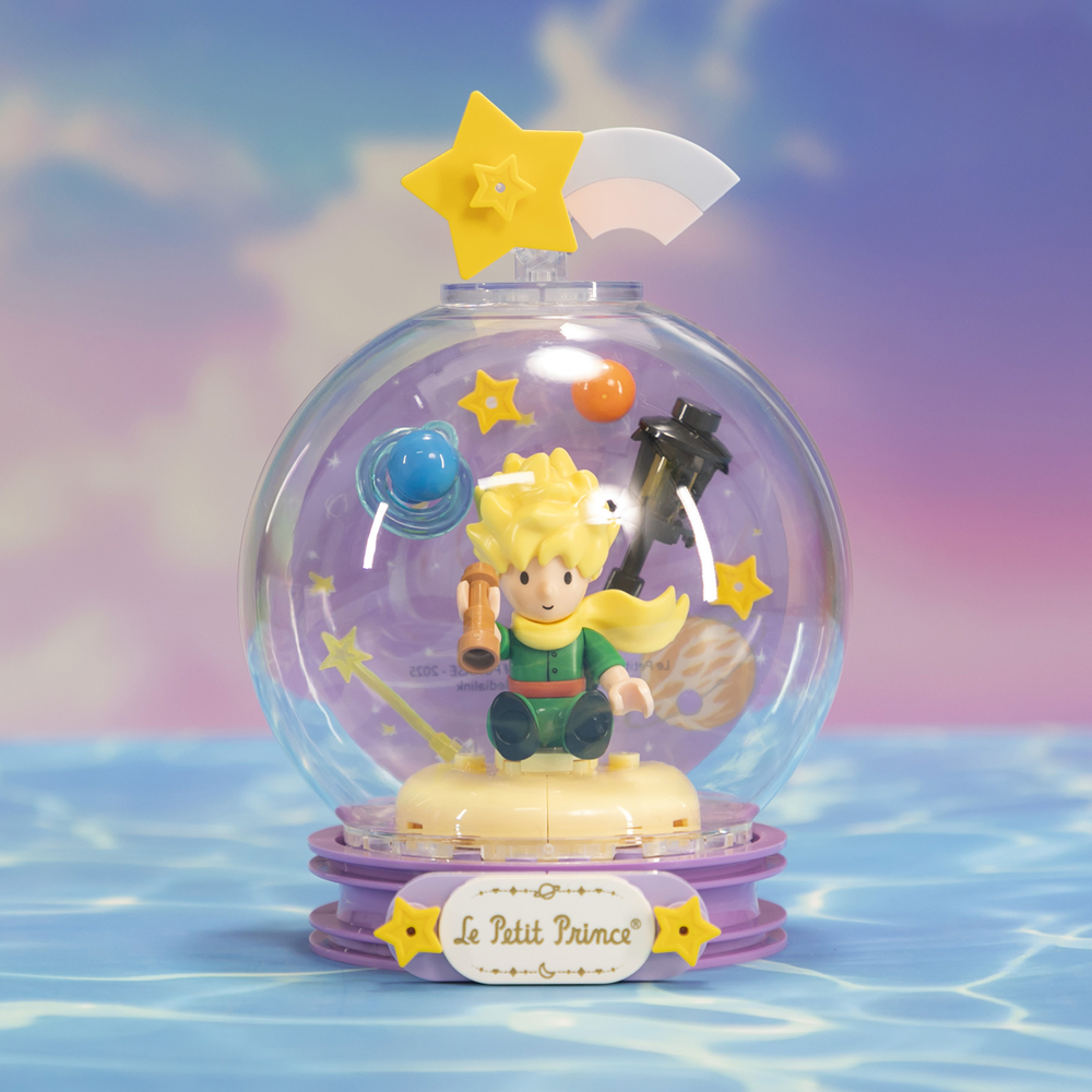 Glowing snow globe with 'Le Petit Prince' character and star on a blue and pink gradient background. Le Petit Prince Starry Lamp brick model kit