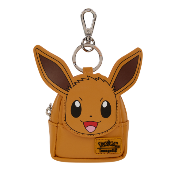 A small tan pouch shaped like Eevee's face, attached to a silver metal clasp keychain. The pouch has embroidered brown ears, large black eyes, a pink mouth, and a yellow 'Pokémon League' patch on the front, shown against a plain white background. Loungefly Pokémon Eevee Mini Backpack Bag Charm