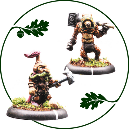 Two painted fantasy tabletop miniatures on round bases against a white background, framed by a dark green circular border with oak leaf graphics. One figure is a small gnome-like character with a pink hat and green beard holding a hammer, and the other is a bear-like creature in a brown hooded suit holding a weapon. Minefolk Bogle King and Kobold by Oakbound Studio 