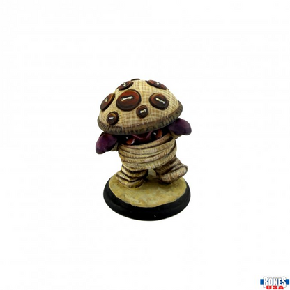 A small fantasy figurine of a mummy-like creature with a mushroom cap on its head, wrapped in bandages, standing on a round black base against a white background.