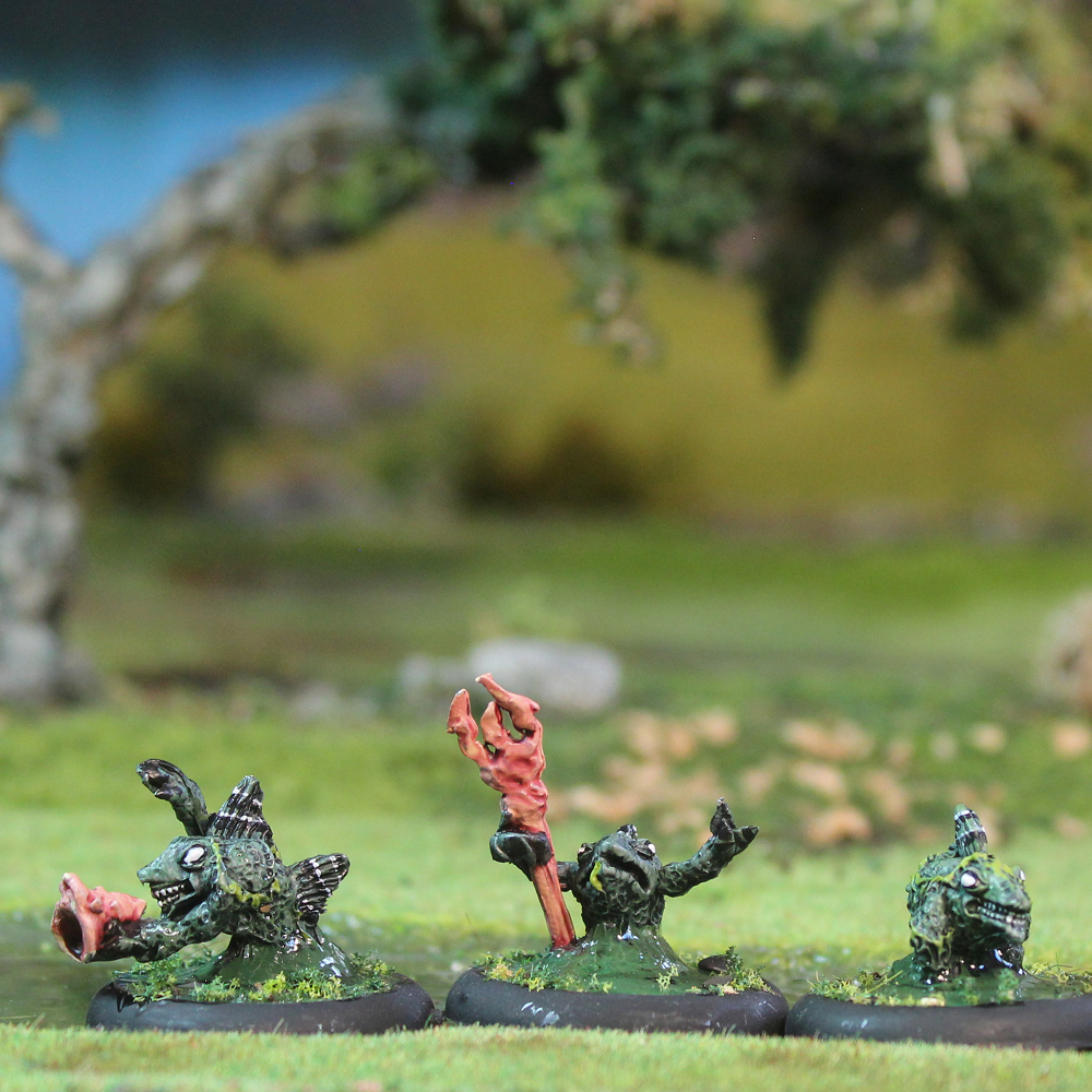 Three Bucca Lurker miniatures, fish-like creatures with one holding a spear and one a shell. 28mm lead pewter unpainted models for fantasy tabletop use.