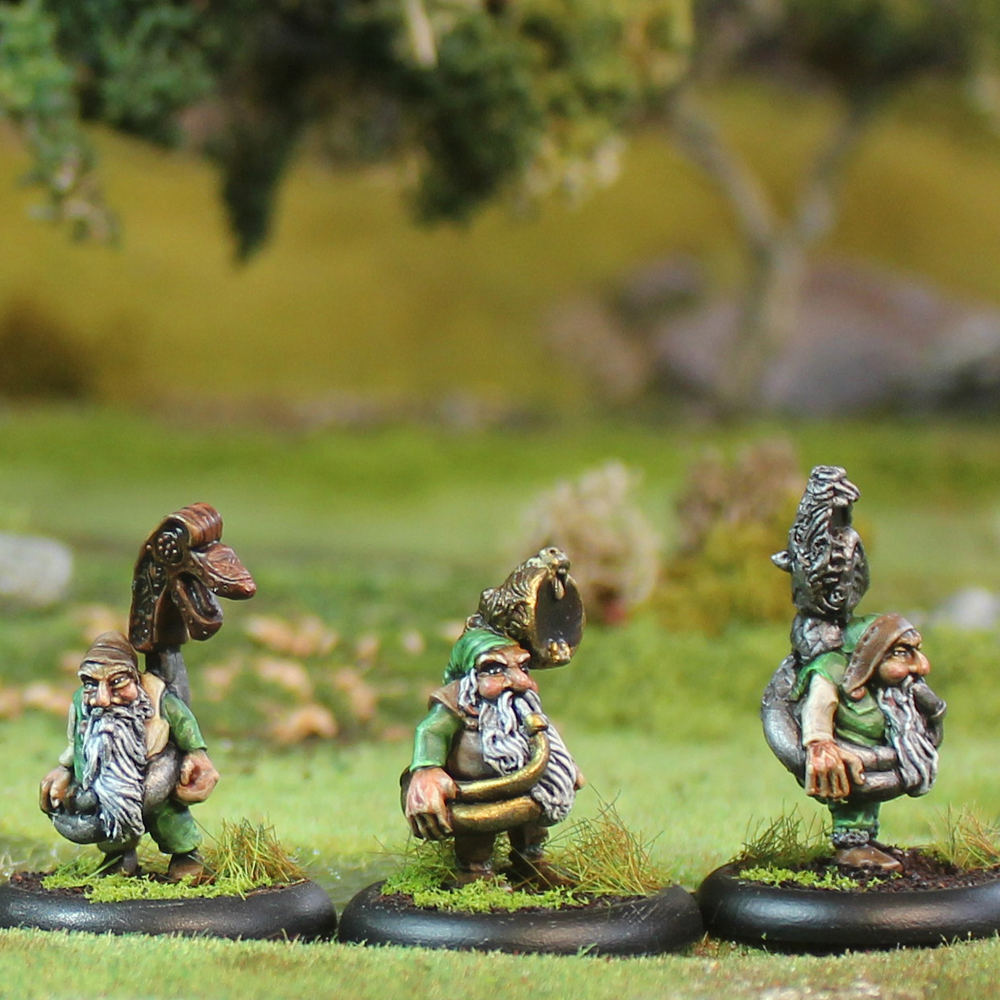 Oakbound Studio Jietna Hornsounders. Three miniature figurines of gnomes on grass with a blurred natural background