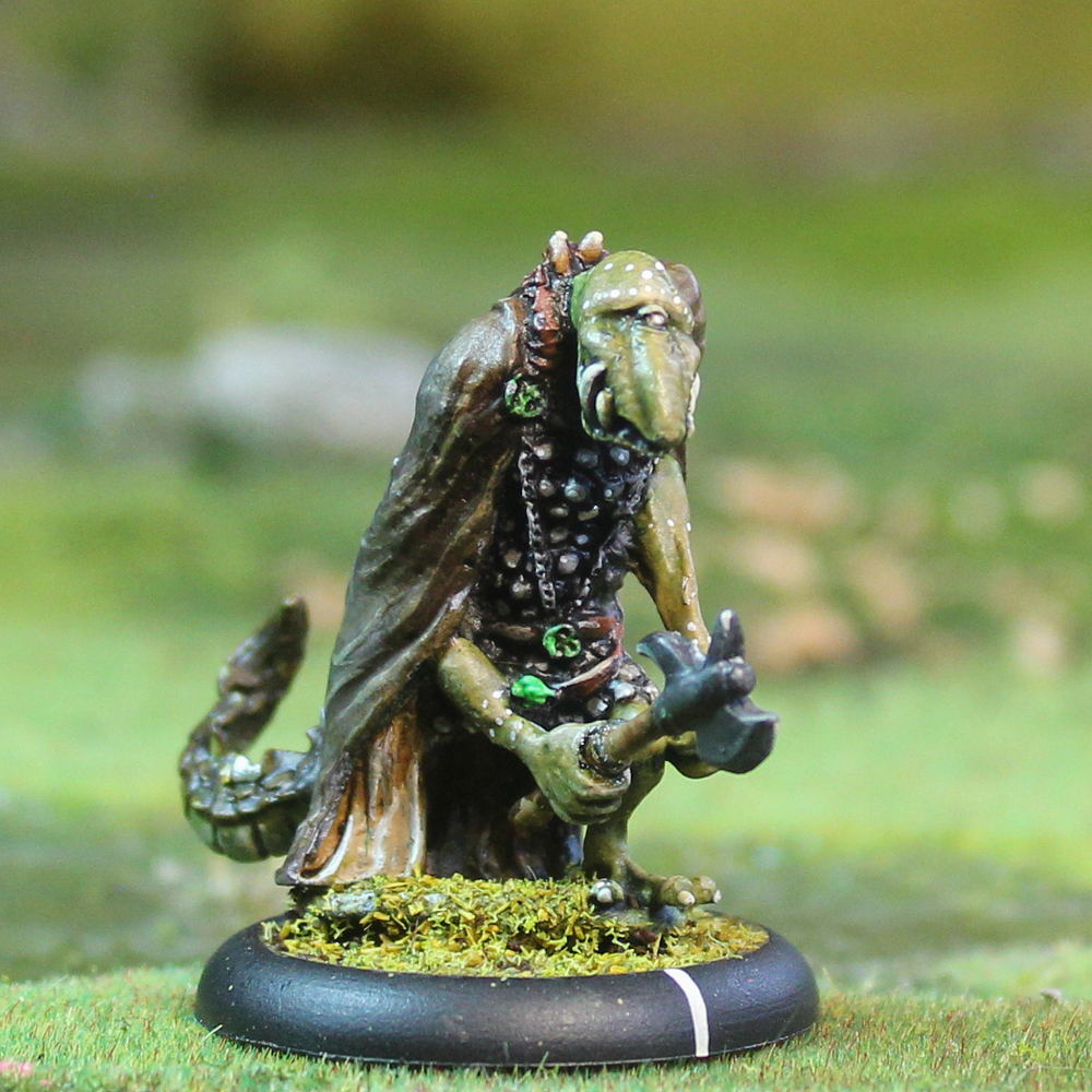 Oakbound Studio Losbast Snaghyrn 1. 28mm Myeri warrior miniature holding an axe, wearing a cloak with a long tail. Lead pewter fantasy figure, unpainted for tabletop wargaming.