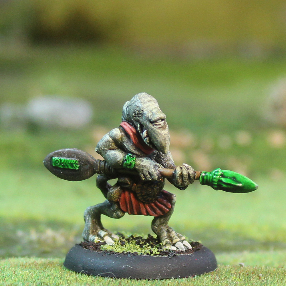 Oakbound Studio Losbast with Hoeroa 1. Miniature figure of a fantasy creature holding a weapon on a grassy background