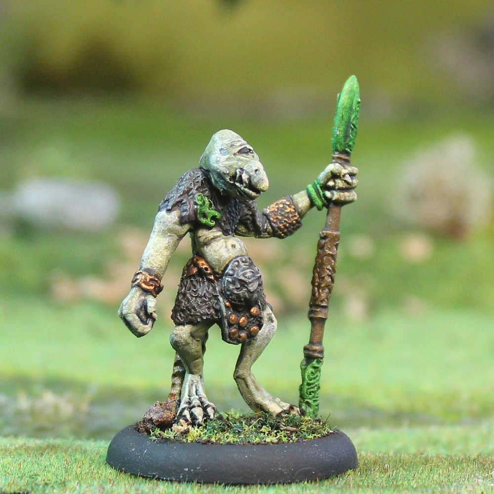 Oakbound Studio Losbast with Hoeroa 2. Miniature figurine of a creature holding a staff on a grassy background