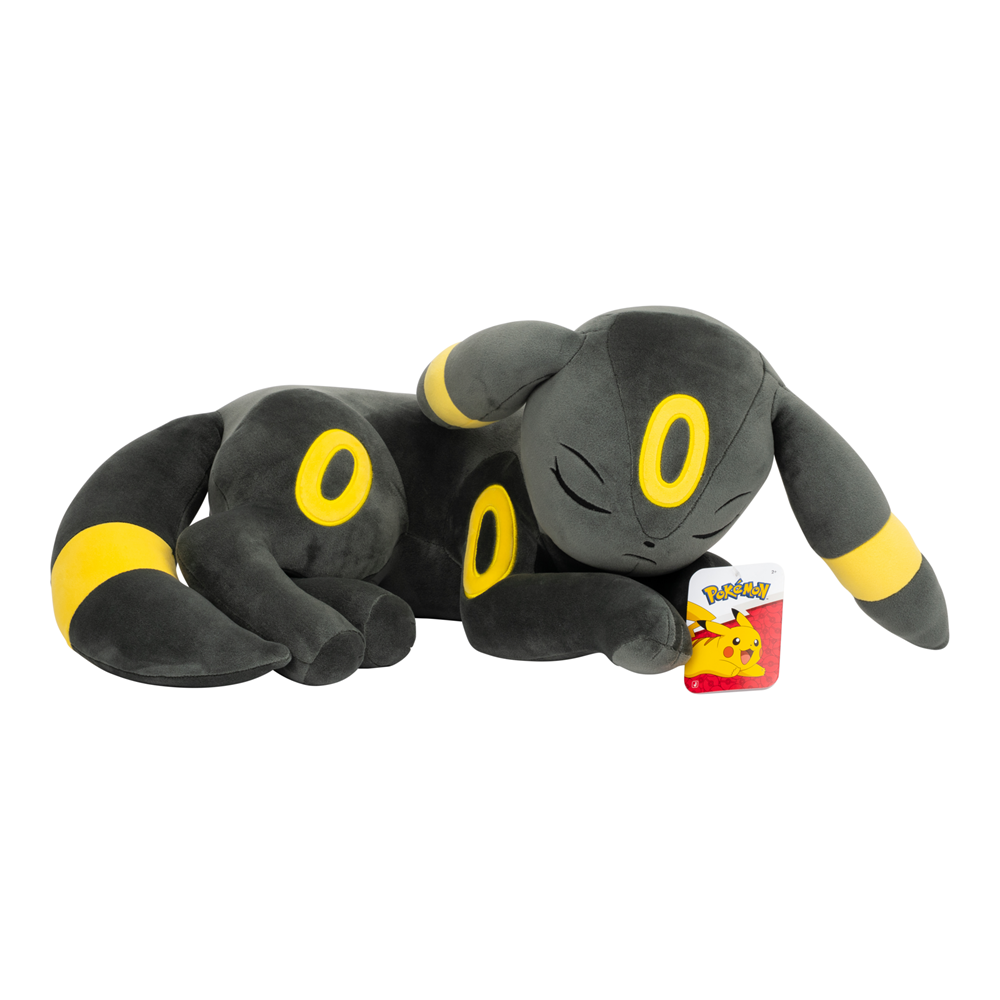 A sleeping Eevee plush toy in black and yellow, lying down next to its red and yellow Pokémon tag on a plain white background. Pokémon Sleeping Umbreon 18 inch plush toy