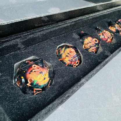 Set of 7 liquid core dice with pumpkins suspended inside, featuring bronze numbers and glitter. Comes in a black case with a view window and magnetic closure.