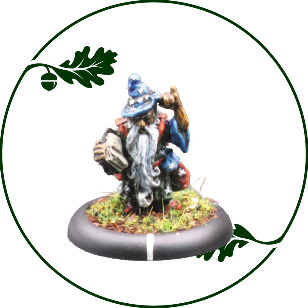 A painted tabletop miniature figurine of a gnome wizard or acorn collector, kneeling on a round base with grass and acorns. The figure wears a blue hat and coat with red and white details, holding an acorn in one hand and gesturing with the other. Skyfolk Mitati by Oakbound Studio