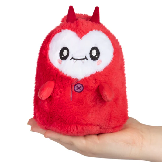 Red plush toy with horns held in a hand on a white background. Squishable Imp Ghost Plush Alter Egos Series 16 soft toy with red suit and heart tail