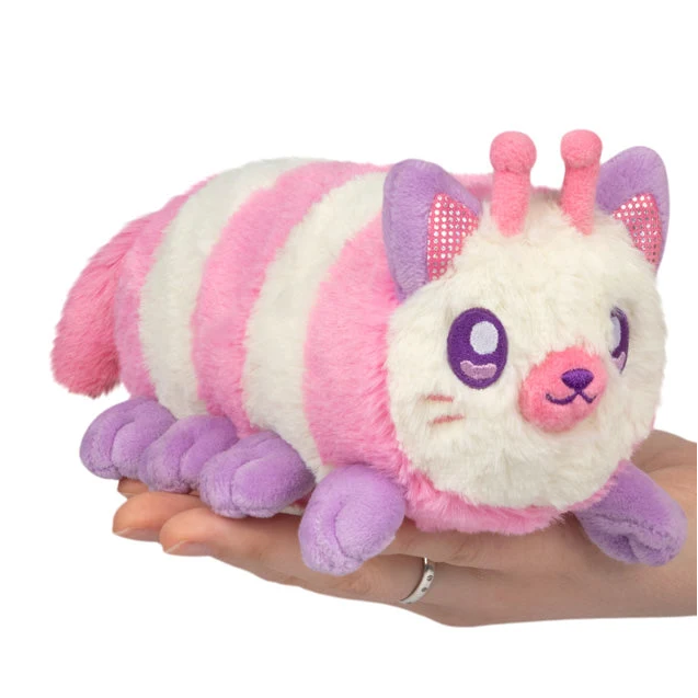 A pink and white striped plush caterpillar toy with purple accents, being held in a person's hand against a plain white background. Squishable Pastel Kittypillar - Snackers S1E3 Limited Edition