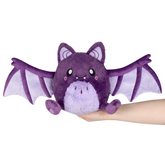 Purple plush bat toy held in a h...