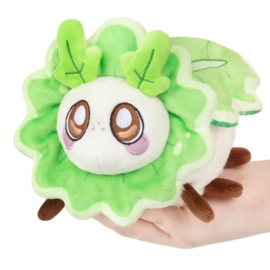 Plush toy resembling a leafy green character held in a hand on a white background. Turnip Moth