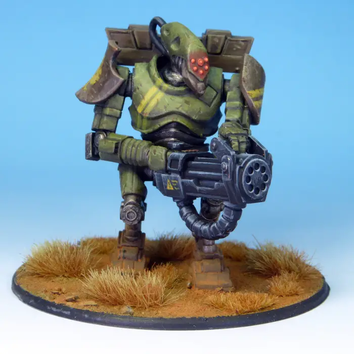 Stargrave Warbot 28mm Scale Metal Miniature. Toy figure in green and brown armour with a weapon on a blue background