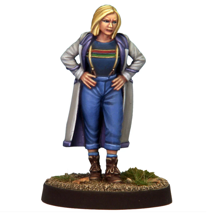 Temporal Traveller 13 by Crooked Dice. 28mm female time traveller miniature with bob haircut, long coat pulled back, jeans with braces and boots, standing hands on hips, ready for action.