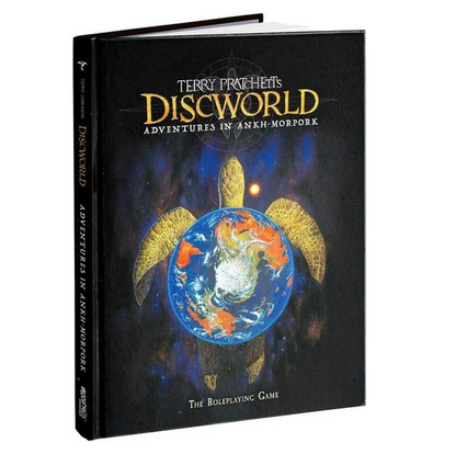 A hardcover book titled "Terry Pratchett's Discworld: Adventures in Ankh-Morpork" shown standing upright at a slight angle on a white background. The cover features a dark space-like background with a large turtle carrying a blue globe, and gold title text. Terry Pratchett's Discworld: Adventures In Ankh-Morpork